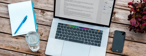 silver MacBook beside space gray iPhone 6 and clear drinking glass on brown wooden top