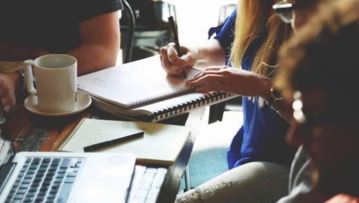 A person sitting at a desk with a computer

Description automatically generated