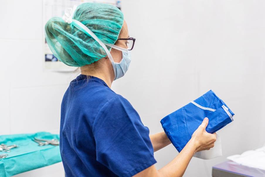 A person wearing a mask and green cap

Description automatically generated