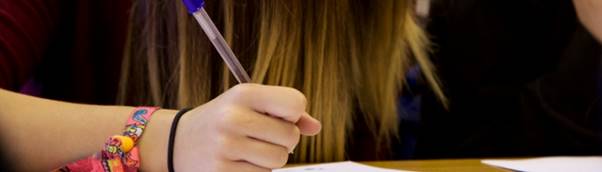 A picture containing a student writing 