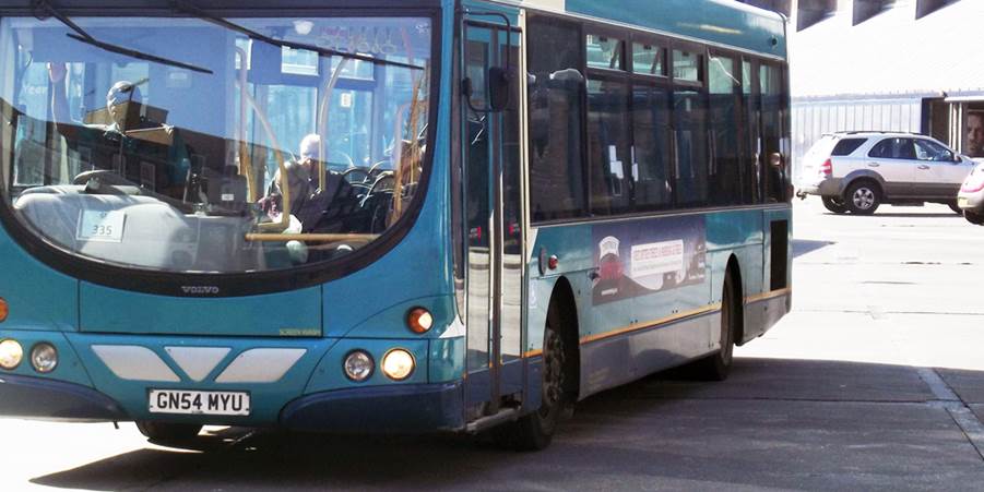 A blue bus parked on the side of the road