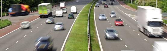 A car driving down a busy highway

Description automatically generated