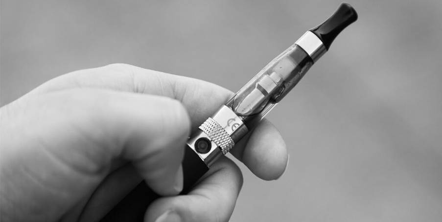 A hand holding a vape pen

Description automatically generated